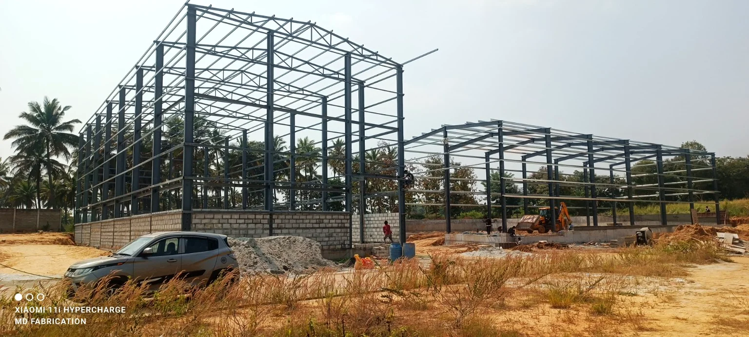 Two large industrial steel frames erected on an open project site.