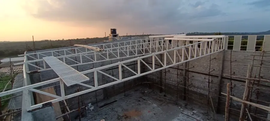 Large roof truss framework installed above a masonry industrial building.