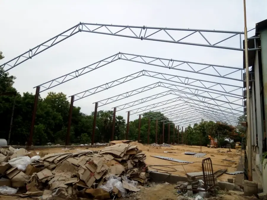 Long-span industrial shed steel frame with repeated roof trusses and columns.