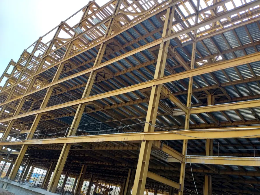 Large multi-level structural steel building frame with metal deck installation.