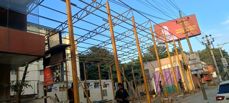 Industrial steel frame under construction along an urban site.