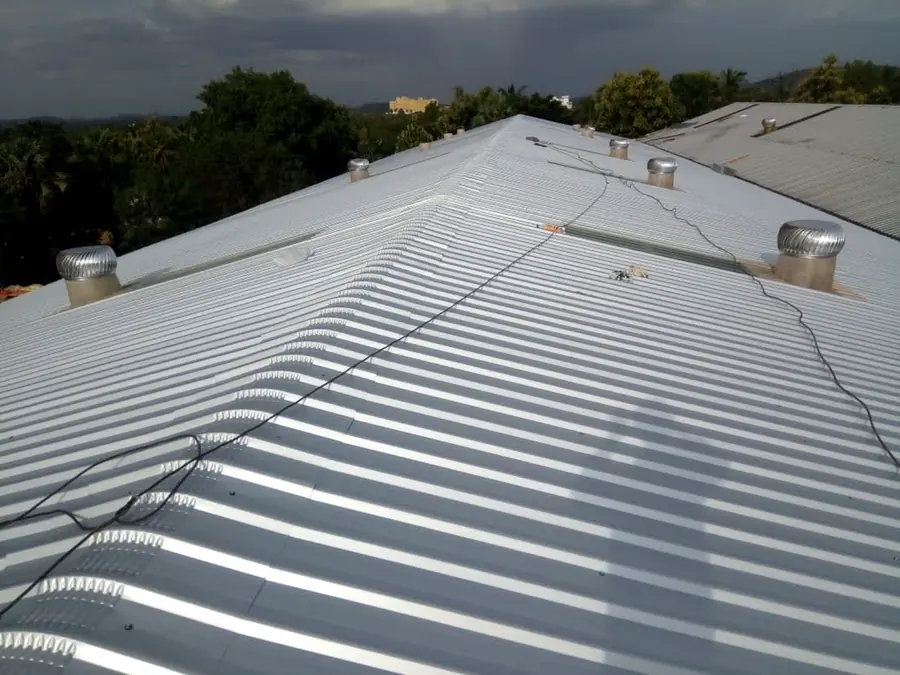 Completed pitched industrial roof with ridge line and ventilation units.
