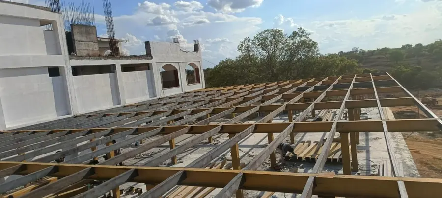 Roof-level steel beam and purlin framing across a large building footprint.