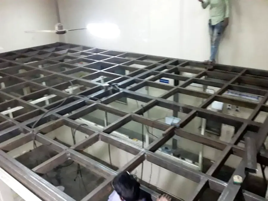 Steel mezzanine frame under construction in a project space.
