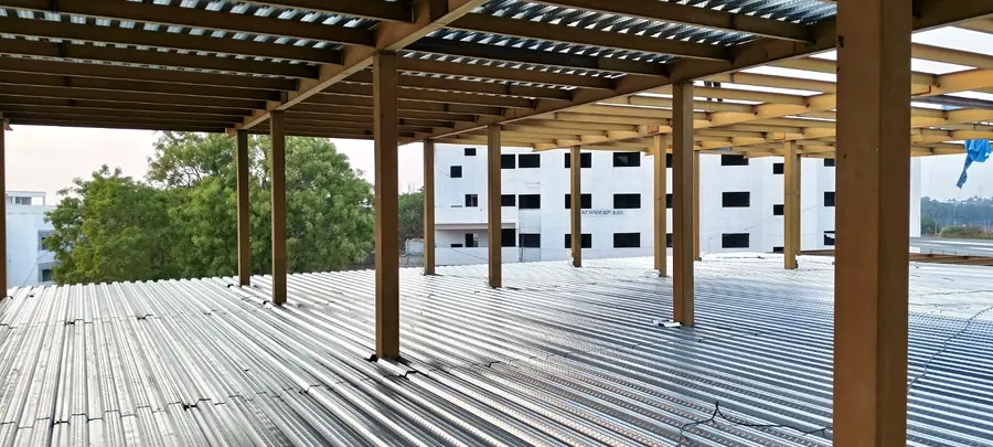 Steel floor framing with galvanized metal deck sheets installed between columns.