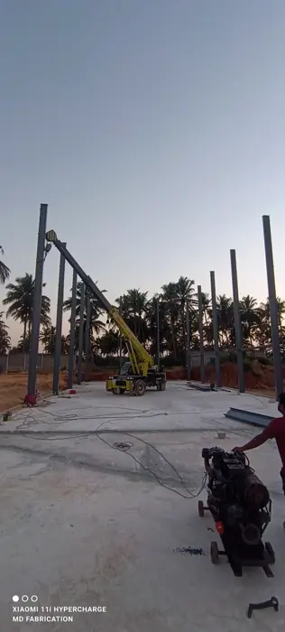 Industrial steel columns being erected with crane support.