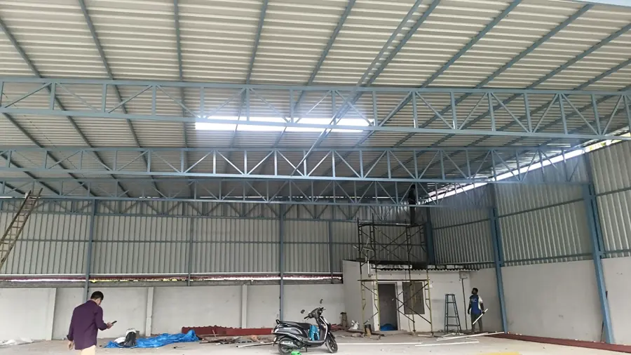 Completed factory shed interior with steel roof trusses and cladding.