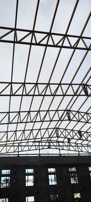 Close interior view of steel roof trusses and purlin arrangement.