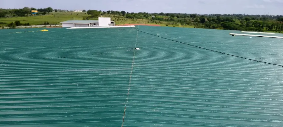 Large green metal industrial roof viewed from above.
